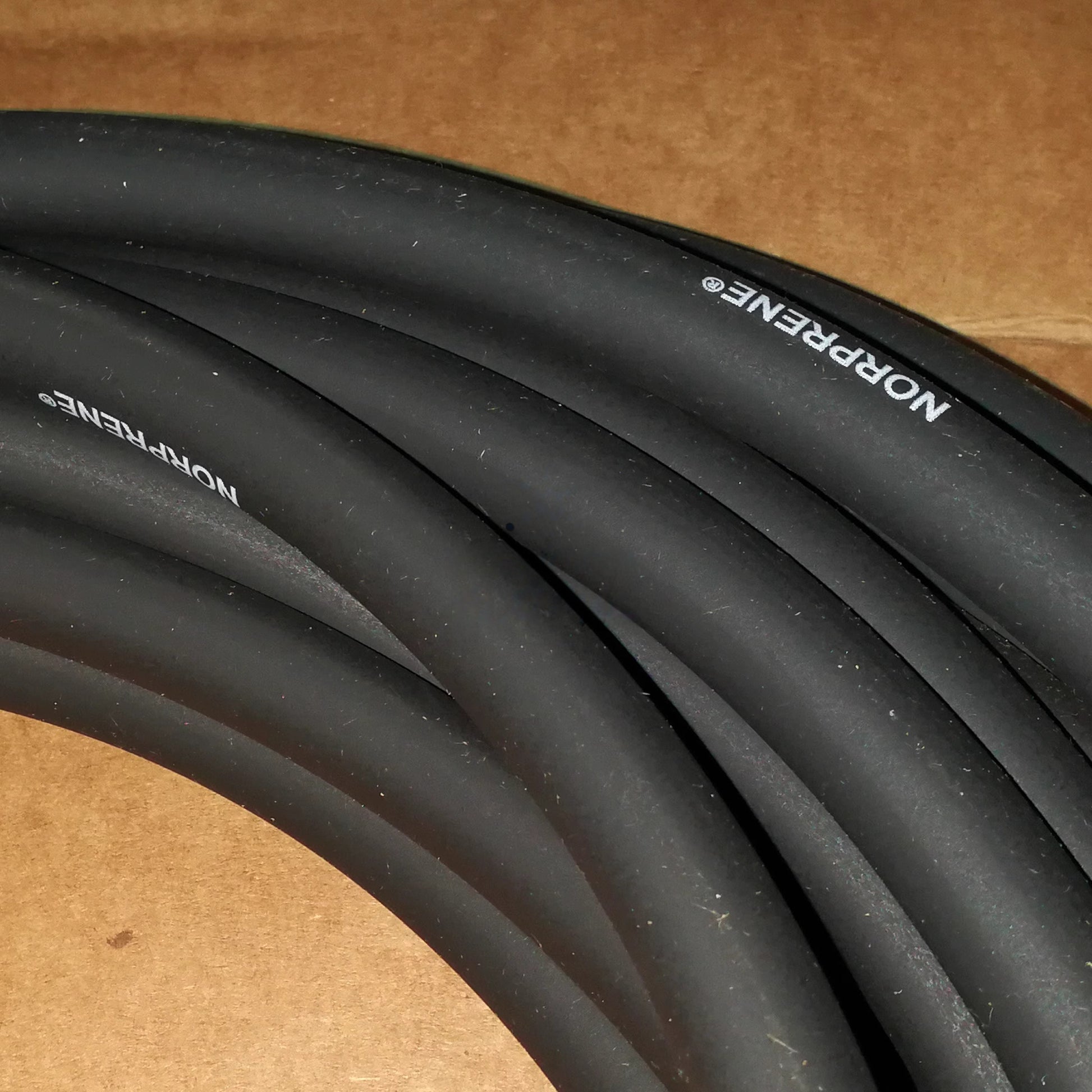 Tygon Norprene A-60-G black peristaltic pump tubing close-up showing NORPRENE brand marking, ink-resistant flexible hose for industrial use
